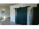Kitchen with modern barn door and stylish, dark green cabinets and adjacent stainless refrigerator at 3065 Ashly Pines Dr, Snellville, GA 30078