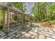 Secluded backyard featuring a shaded pergola, stone patio, and lush, mature trees at 1290 Fernwood Ne Cir, Brookhaven, GA 30319