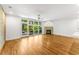 Open living room with hardwood floors, brick fireplace, and large windows overlooking the outdoor space at 1290 Fernwood Ne Cir, Brookhaven, GA 30319