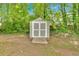 Backyard with a gray shed featuring a wooden base and double doors for storing gardening supplies at 3463 Chastain Glen Ne Ln, Marietta, GA 30066