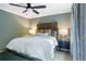 Bedroom with soft green walls, two windows for wooded views, and a decorative ceiling fan at 4094 Norton Se Pl, Smyrna, GA 30082