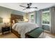 Bedroom with soft green walls, two windows for wooded views, and a decorative ceiling fan at 4094 Norton Se Pl, Smyrna, GA 30082