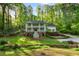 Two-story home with a double porch, surrounded by lush greenery and mature trees at 4094 Norton Se Pl, Smyrna, GA 30082