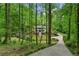 Scenic shot of a two-story home nestled among tall trees with a winding driveway at 4094 Norton Se Pl, Smyrna, GA 30082