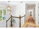 Upstairs hallway featuring paneled walls, hardwood floors and a window with wooded views at 4094 Norton Se Pl, Smyrna, GA 30082