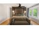 Bedroom featuring a decorative upholstered wall, hardwood floors, and a bay window with backyard views at 4094 Norton Se Pl, Smyrna, GA 30082