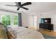 Bright main bedroom features a ceiling fan, large windows with wooded views, and hardwood floors at 4094 Norton Se Pl, Smyrna, GA 30082