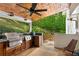 Outdoor kitchen featuring a grill, counters, wood ceiling, and wooded scenery at 4094 Norton Se Pl, Smyrna, GA 30082