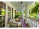 Inviting porch with cozy seating, white columns, ferns, and serene views of nature at 4094 Norton Se Pl, Smyrna, GA 30082