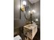 Stylish powder room features a marble sink, unique gold fixtures, and modern gray wall paneling at 4094 Norton Se Pl, Smyrna, GA 30082