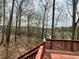 Wooden deck with railings overlooking a serene backyard surrounded by tall trees, providing a sense of privacy at 602 Springharbor Dr, Woodstock, GA 30188