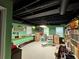 Basement with green walls, black ceiling, large bookshelves and carpeted floors at 602 Springharbor Dr, Woodstock, GA 30188