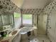 Bright bathroom featuring a large tub, separate shower, and vanity with classic floral wallpaper at 602 Springharbor Dr, Woodstock, GA 30188