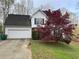 Charming two-story home with an attached garage and a well-maintained front yard with a beautiful red tree at 602 Springharbor Dr, Woodstock, GA 30188