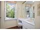 Bright bathroom features a large window with shutters, a vanity, and hardwood floors at 1011 W Paces Ferry Nw Rd, Atlanta, GA 30327