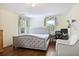 Well-lit bedroom with hardwood floors, a tufted gray bed, and multiple windows at 1011 W Paces Ferry Nw Rd, Atlanta, GA 30327