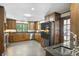 Traditional kitchen features wood cabinets, black appliances, and large window for natural light at 1011 W Paces Ferry Nw Rd, Atlanta, GA 30327