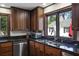 Kitchen area with stainless steel dishwasher, dark countertops, and view of the backyard at 1011 W Paces Ferry Nw Rd, Atlanta, GA 30327