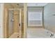 Spa-like bathroom with a glass-enclosed shower and a separate soaking tub by a sunny window at 4280 Azurite St, Cumming, GA 30040