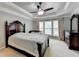 Comfortable main bedroom featuring a tray ceiling, fan, and a large window with curtain accents at 4280 Azurite St, Cumming, GA 30040