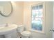 Cozy powder room features a white vanity, toilet, round mirror, and a window with natural light at 429 Gold Xing, Canton, GA 30114