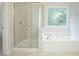 Bathroom featuring glass enclosed shower and separate white tub and tile flooring at 429 Gold Xing, Canton, GA 30114