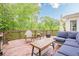 Relaxing back deck featuring patio furniture, wooden railing, and a beautiful wooded view at 745 Amberton Close, Suwanee, GA 30024