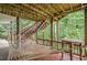 Relaxing back porch with a hammock, wooden beams and stairs leading to the yard at 745 Amberton Close, Suwanee, GA 30024