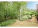 Beautiful backyard with mature trees, green grass and wooden steps leading to a creek at 745 Amberton Close, Suwanee, GA 30024
