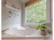 A view of the bathtub area, showcasing the large window and natural light in the bathroom at 745 Amberton Close, Suwanee, GA 30024
