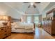 The bedroom boasts a large bed, hardwood floors, and a ceiling fan for added comfort and style at 745 Amberton Close, Suwanee, GA 30024