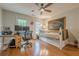The bedroom boasts hardwood floors, large windows, and a ceiling fan for added comfort and style at 745 Amberton Close, Suwanee, GA 30024
