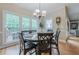 Dining area features large windows with wooded view and traditional chandelier lighting at 745 Amberton Close, Suwanee, GA 30024