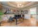Elegant dining room featuring hardwood floors, a tray ceiling, wainscoting and a grand piano at 745 Amberton Close, Suwanee, GA 30024