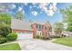 Charming brick home with a well-manicured lawn and an attached two-car garage at 745 Amberton Close, Suwanee, GA 30024