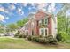 Traditional brick home featuring manicured landscaping, lush green grass, and classic architectural details at 745 Amberton Close, Suwanee, GA 30024