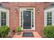 Close-up of the brick home's elegant front door entrance with decorative sidelights and mature landscaping at 745 Amberton Close, Suwanee, GA 30024