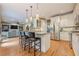 Open kitchen with stainless appliances, pendant lights, and breakfast bar flows into living area at 745 Amberton Close, Suwanee, GA 30024