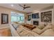 Open-concept living room with fireplace, built-ins and view of sunroom through large window at 745 Amberton Close, Suwanee, GA 30024