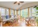 Inviting sunroom filled with natural light, featuring wicker furniture and hardwood floors at 745 Amberton Close, Suwanee, GA 30024