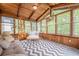 Cozy sunroom with wood paneled walls and ceiling, large windows and comfortable seating at 745 Amberton Close, Suwanee, GA 30024
