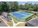 Aerial view of community tennis courts featuring blue playing surface and surrounding trees at 745 Amberton Close, Suwanee, GA 30024