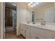 Well-lit bathroom featuring a double vanity and a separate door leading to a shower and toilet at 1655 Holly Lake Cir, Snellville, GA 30078