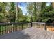 Spacious wooden deck with black railings and green trees surrounding at 2875 Riverbend Ct, Snellville, GA 30078
