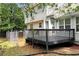 A wooden backyard deck with black railings leading to a chain link fence surrounding the yard at 2875 Riverbend Ct, Snellville, GA 30078