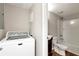 Functional bathroom with shower-tub combo and a laundry machine at 2875 Riverbend Ct, Snellville, GA 30078