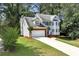 Charming two-story home with blue shutters and a well-manicured lawn and attached two car garage at 2875 Riverbend Ct, Snellville, GA 30078