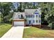 Charming two-story home with blue shutters and a well-manicured lawn and attached two car garage at 2875 Riverbend Ct, Snellville, GA 30078