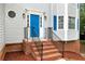 Charming front entrance with a blue door, brick steps, and black metal railing at 2875 Riverbend Ct, Snellville, GA 30078