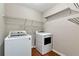 Efficient laundry room featuring a modern washer and dryer with ample shelving space at 2875 Riverbend Ct, Snellville, GA 30078